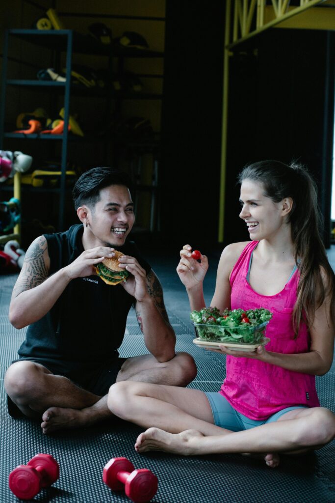 Man and woman eating a healthy nutritiousmeal together after a fitness workout