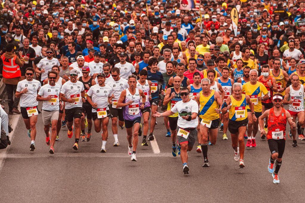 Running Distances Explained: From Your First 1K to Crossing the Marathon Finish Line A large crowd of marathon runners lined up at the starting line of a race.